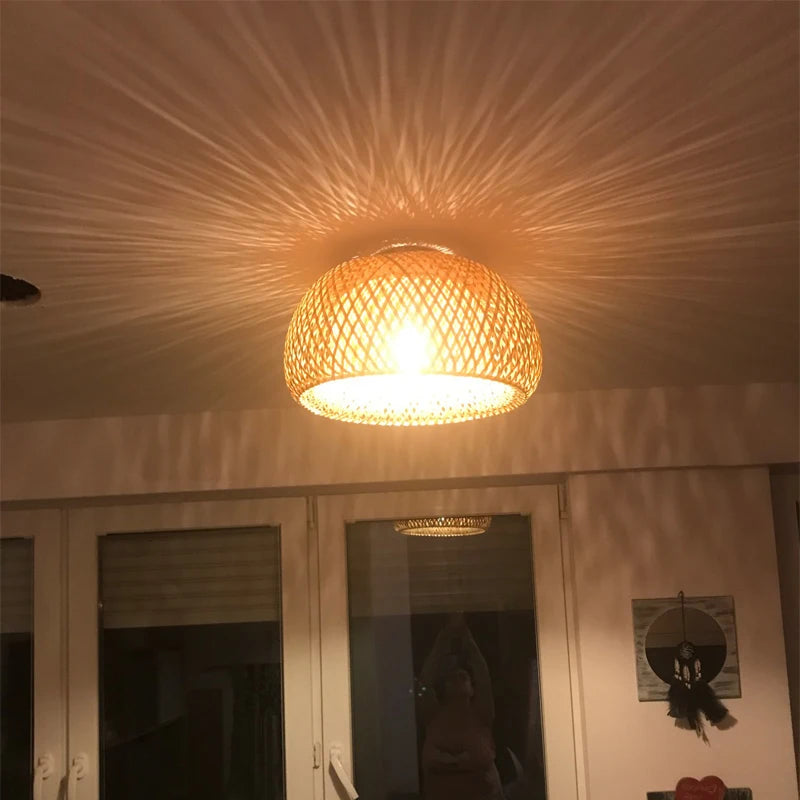 Bamboo ceiling light with intricate weave creating a starburst shadow pattern on a white ceiling.