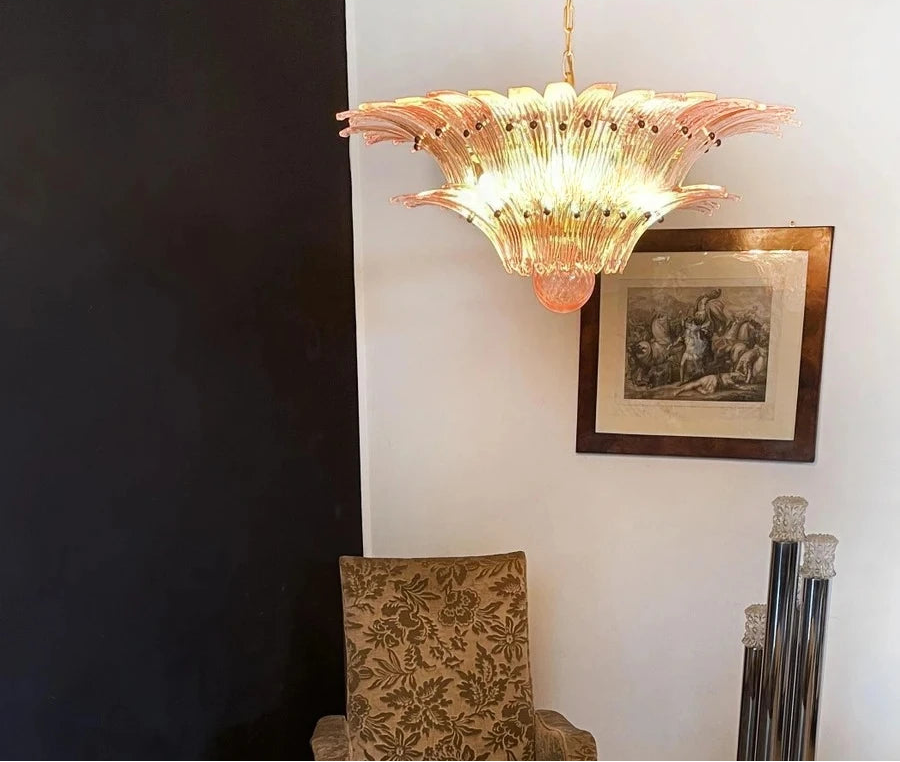 Decorative chandelier hanging in a room with a chair and framed picture on the wall.