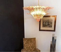 Decorative chandelier hanging in a room with a chair and framed picture on the wall.