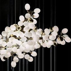 A detailed view of the gold grapes bunch chandelier's structure and illuminated bulbs against a dark background.