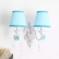 White double wall sconce with blue pleated fabric shades, adorned with blue roses and crystal droplets.