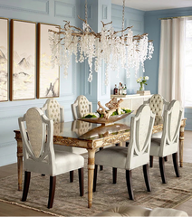 Elegant dining room with a large ornate table, chairs, and decorative elements.