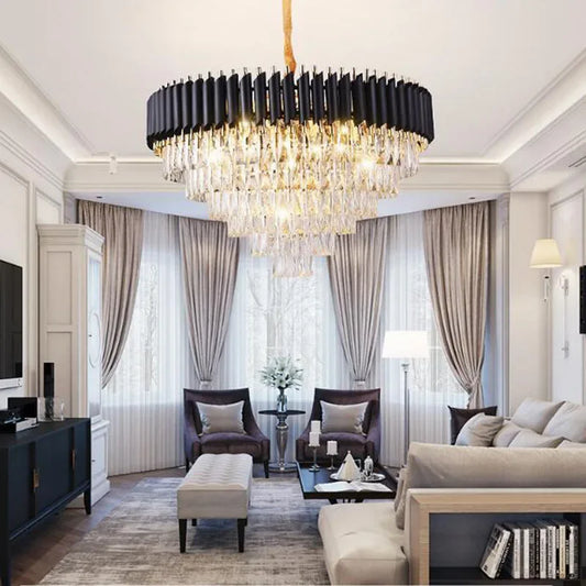 A large, tiered crystal chandelier with a gold frame hangs from a ceiling in a modern living room.