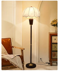 Floor lamp in a room with a chair and decorative items.