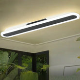 Long, thin, white and black linear ceiling light mounted on a neutral ceiling.