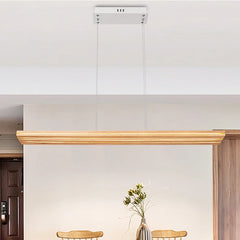 Wooden cornice on a white wall with a vase of flowers below.