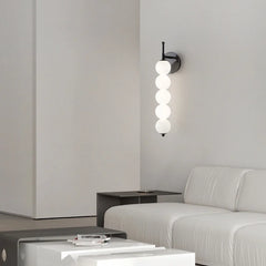 Modern wall sconce with three spherical lights in a minimalistic living room.