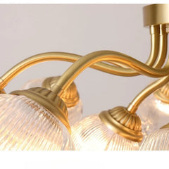 Gold chandelier with glass shades on a neutral background