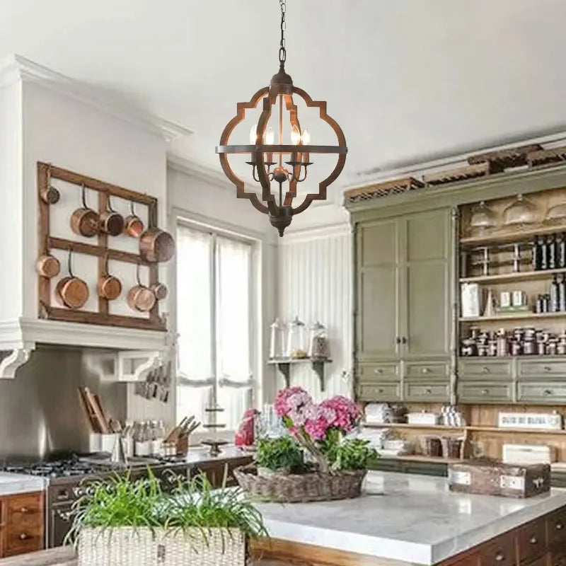 Modern kitchen with green cabinets, marble countertops, and copper pots on a wooden rack.