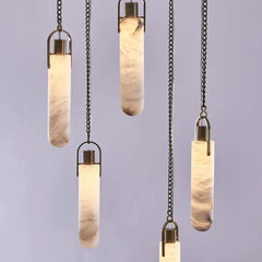 Set of pendant lights with cylindrical glass shades on a plain background