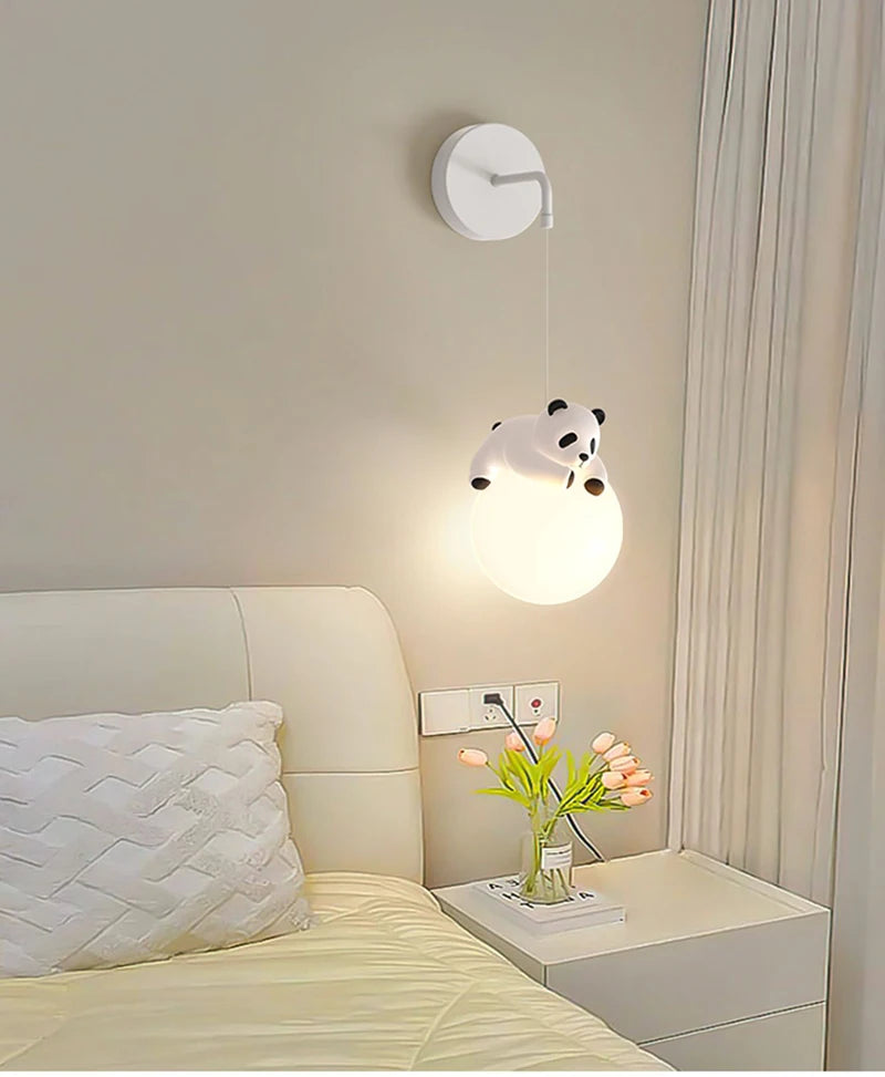 Panda-shaped pendant light above a bed in a bedroom setting