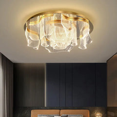 Gold floral wave LED ceiling light installed above a bed in a bedroom with dark accent walls.