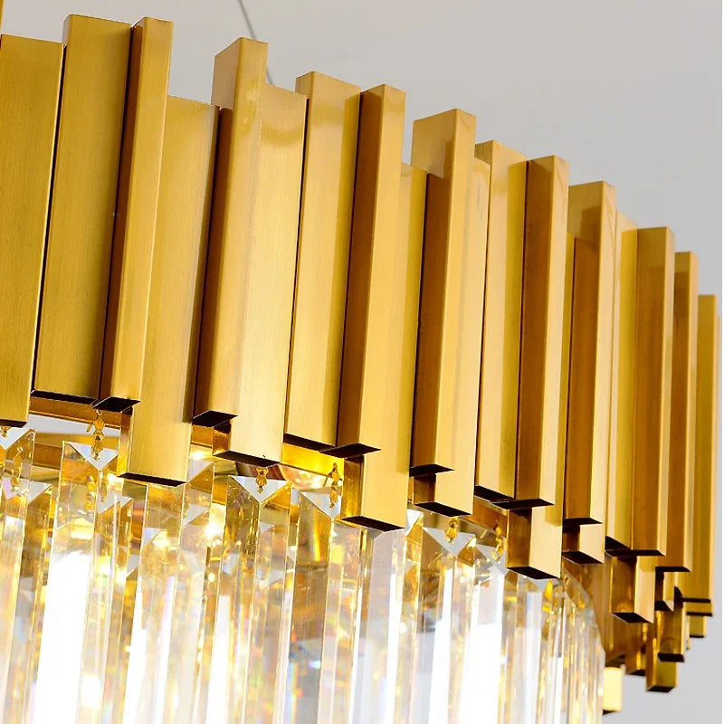 Detail shot of the gold metal frame and hanging crystals of a modern chandelier.