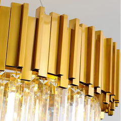 Detail shot of the gold metal frame and hanging crystals of a modern chandelier.