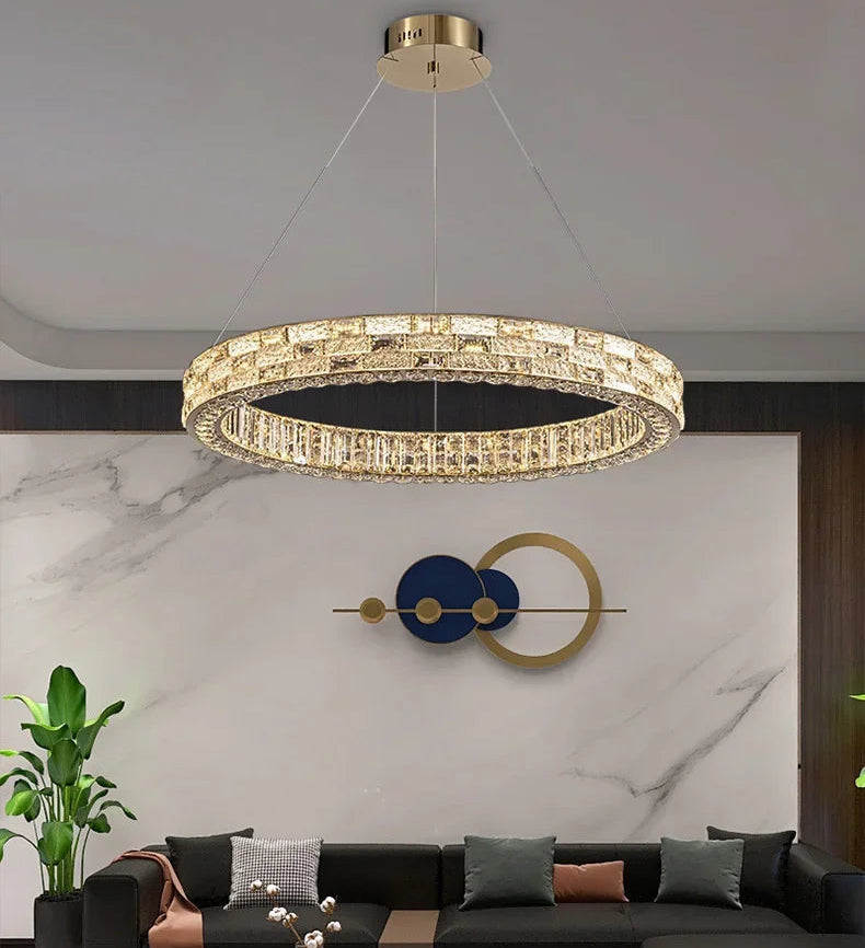 Modern chandelier hanging in a living room with a black sofa and decorative wall art.