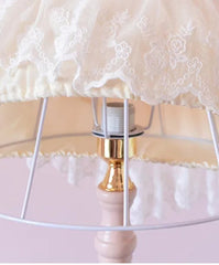 Decorative lamp with lace shade on a pink background