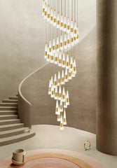 Modern chandelier hanging in a stylish interior setting with stairs and decor items.