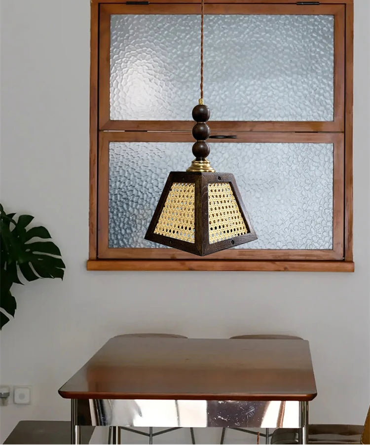 Wooden pendant light hanging in front of a glass-paneled wooden window.