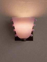 Wall-mounted light fixture with pink glass shade on a gray background