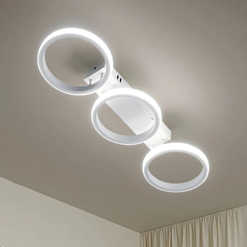 Underside view of a white LED ceiling light featuring three circular rings mounted on a rectangular base.