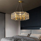 A gold and crystal chandelier with stacked cube-shaped crystals hanging in a modern bedroom.