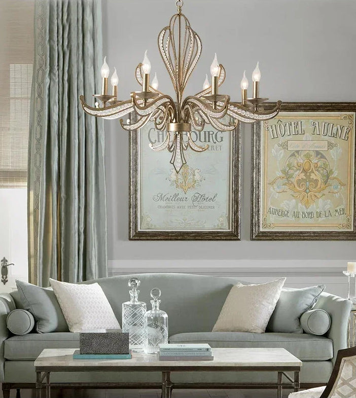 Living room with a chandelier, gray sofa, and framed artwork.