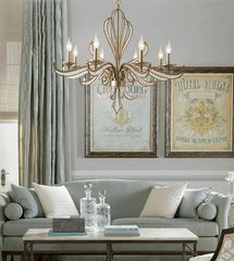 Living room with a chandelier, gray sofa, and framed artwork.