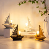 Decorative sailboat lamps on a shelf with a warm glow.