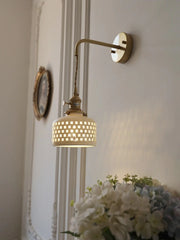 Wall-mounted lamp with decorative shade in a home setting