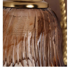 Close-up view of the textured amber glass shade of a floral wall sconce, showing ribbed detail.