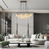 A modern living room with a gold chandelier featuring multiple suspended marble-effect globes.
