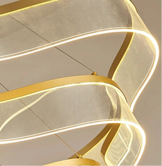 Modern gold pendant light fixture on a neutral background