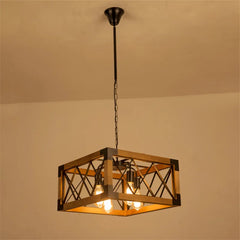 Square industrial chandelier with wood frame and dark metal cage, featuring four exposed bulbs, suspended by a chain from a ceiling canopy.