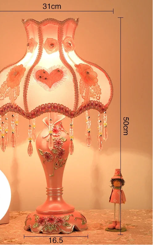 Decorative pink lamp with floral design on a beige background
