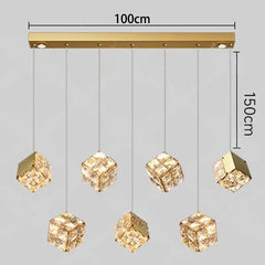 Gold pendant light fixture with crystal-like shades and dimensions on a gray background
