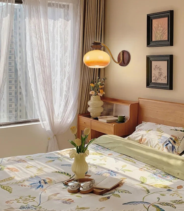 Bedroom with floral bedspread, nightstand, and wall decor.
