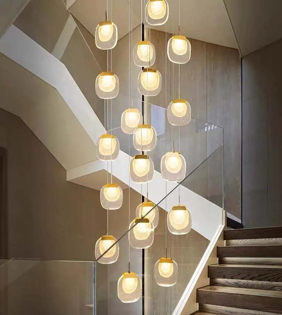 Modern chandelier hanging over a staircase in a home interior.
