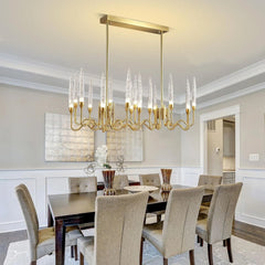 Dining room with a gold chandelier, table, and chairs.