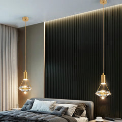 Modern bedroom with hanging gold pendant lights, gray bedding, and a textured black wall.