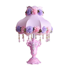 Pink table lamp with floral design on a white background
