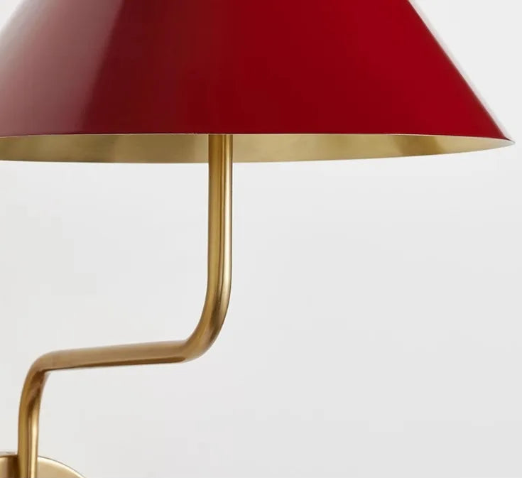 Table lamp with red shade and gold base on a white background
