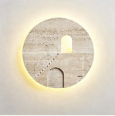 Round natural stone wall sconce with a carved staircase and archway illuminated by warm LED light from behind.