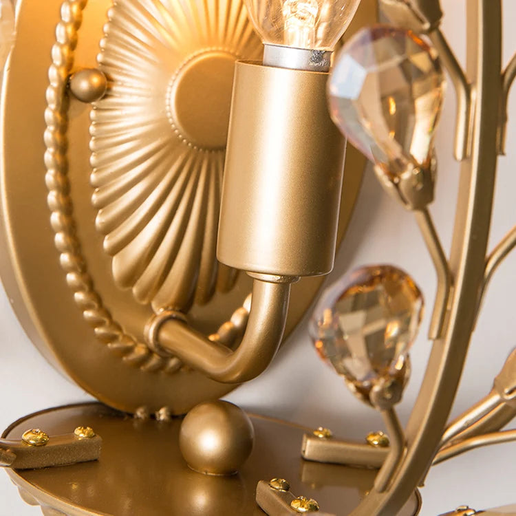 Close-up of a gold decorative wall light fixture with crystal accents.