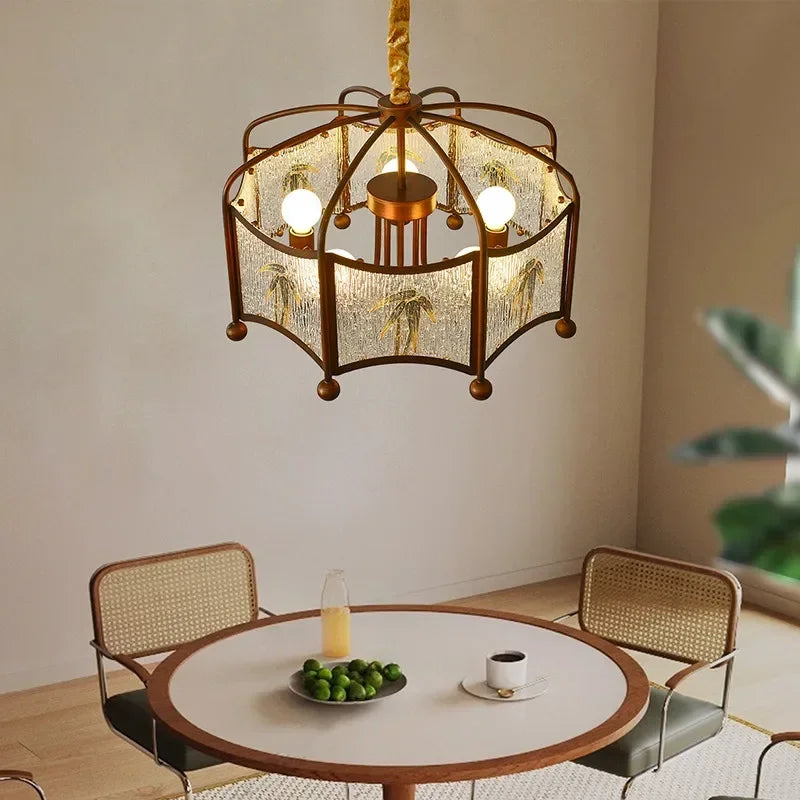 A collection of brushed gold pendant lights with floral motifs and frosted glass, displayed in various room settings.