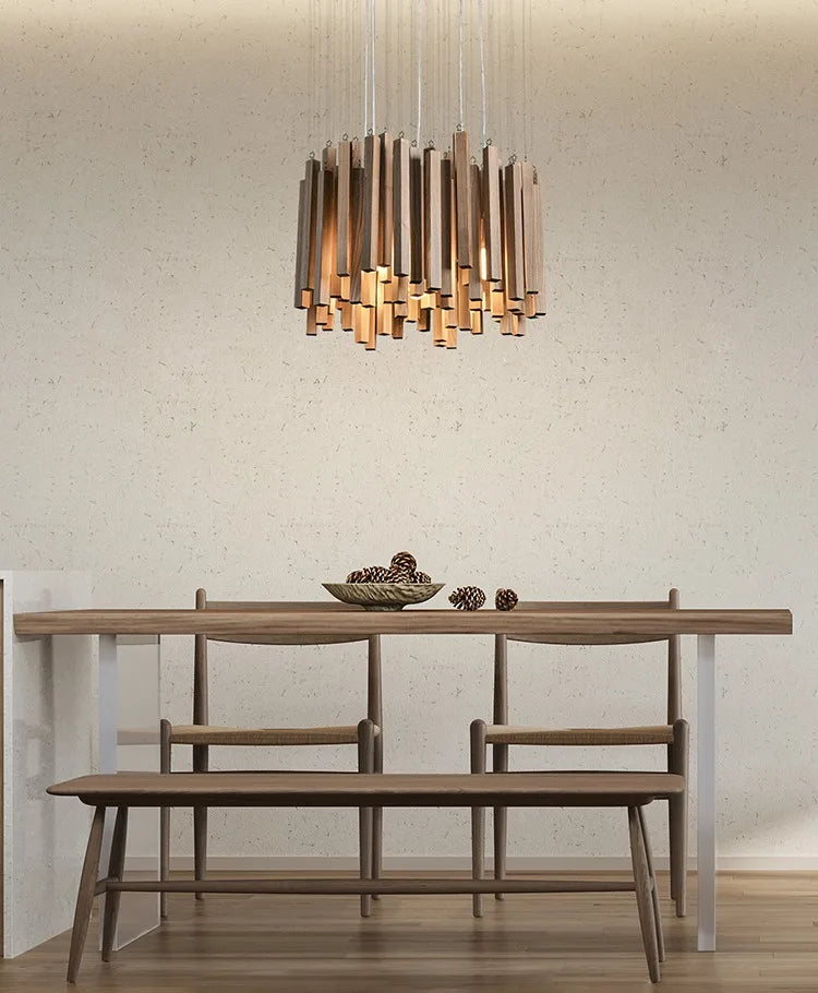 Dining room with wooden table, chairs, and bench under a modern chandelier.