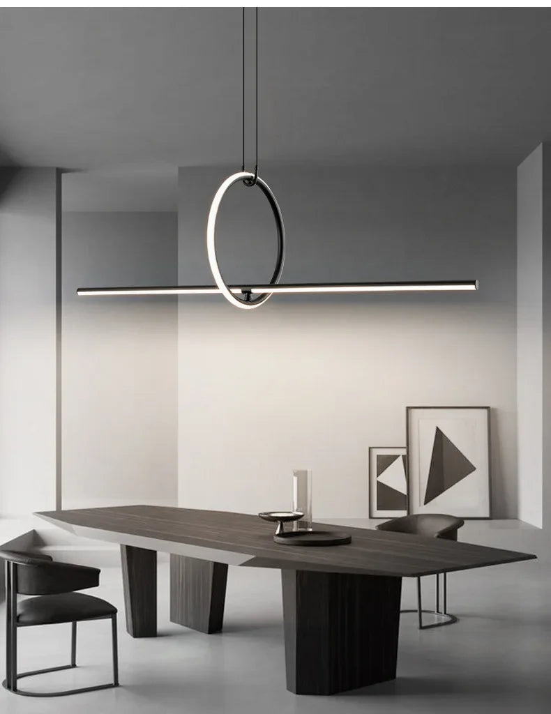 Modern dining table with chairs and a stylish pendant light in a minimalistic room.