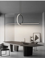 Modern dining table with chairs and a stylish pendant light in a minimalistic room.