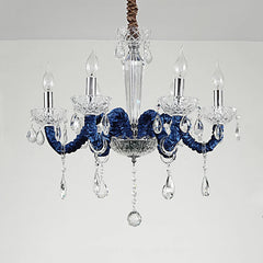 Close-up view of a 6-head chandelier showcasing its chrome arms, clear crystal pendants, and candle-style light sockets.