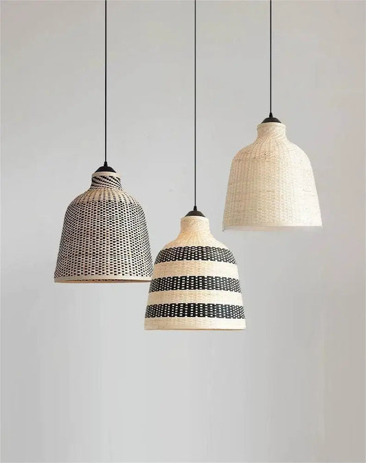 Three rattan woven bell pendant lights hanging against a white wall