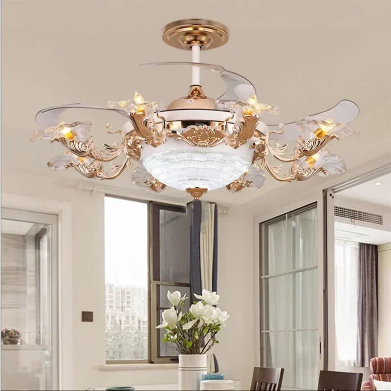 A close-up view of a gold ceiling fan light with ornate floral accents and clear crystal embellishments, set against a white ceiling.